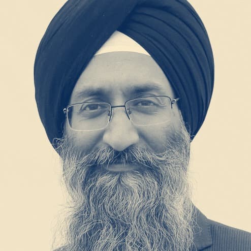 Suneet Singh Tuli, in a black dastar and glasses, in a professional headshot.